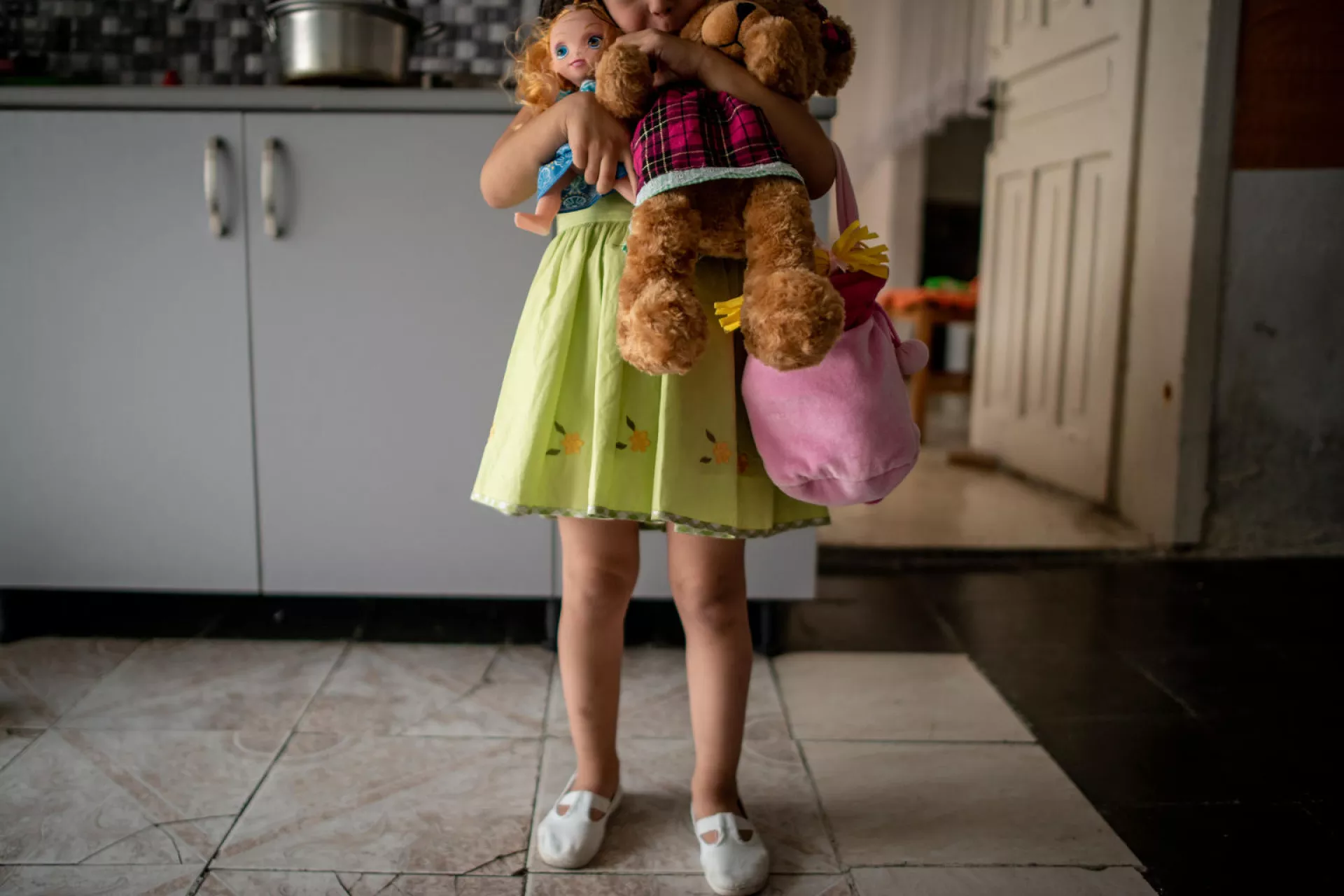 A child holds her stuffed bear.